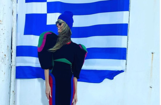 Supermodel Heidi Klum strikes a pose in front of the Greek flag on Mykonos